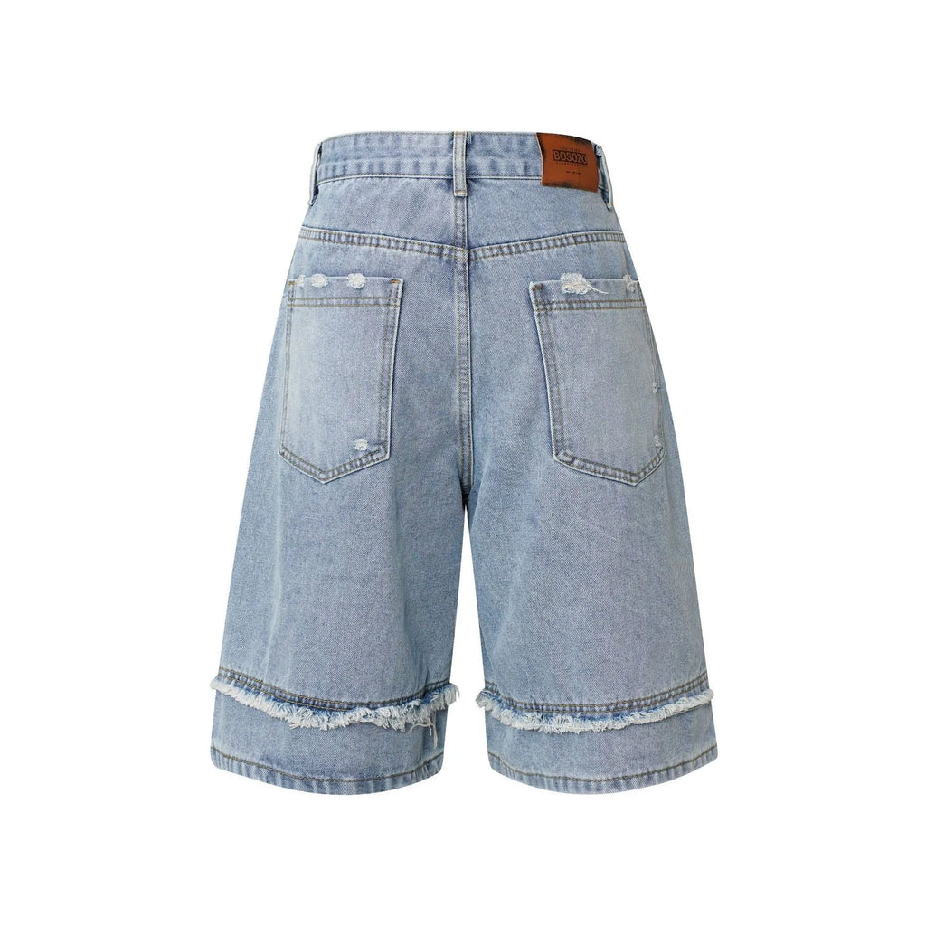 Man wearing distressed light blue denim shorts with raw edge hem and straight hip hop cut.