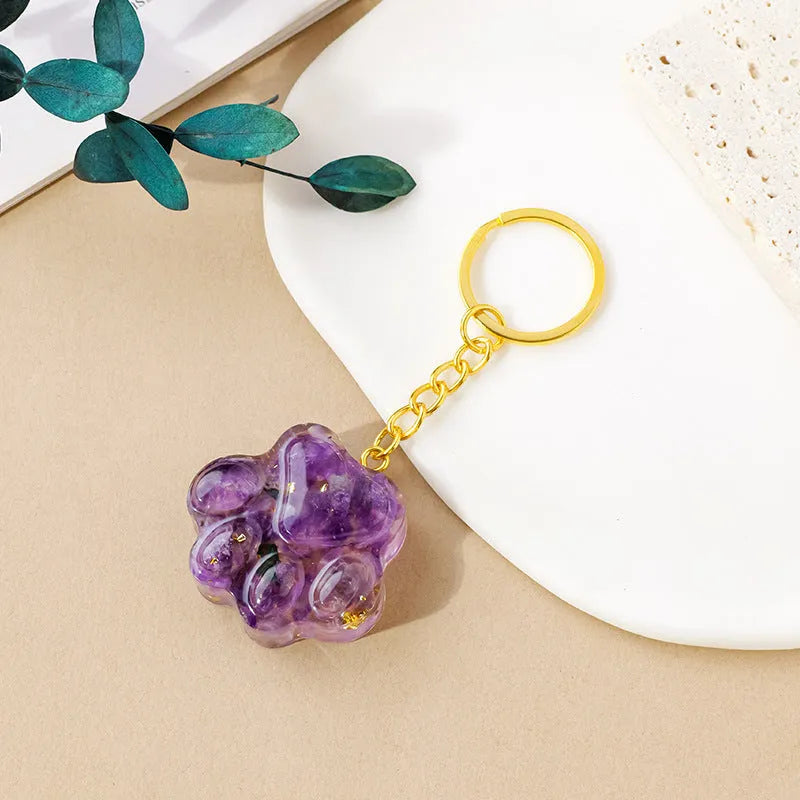Small natural crystal cat's paw keychain pendant on a metal ring.