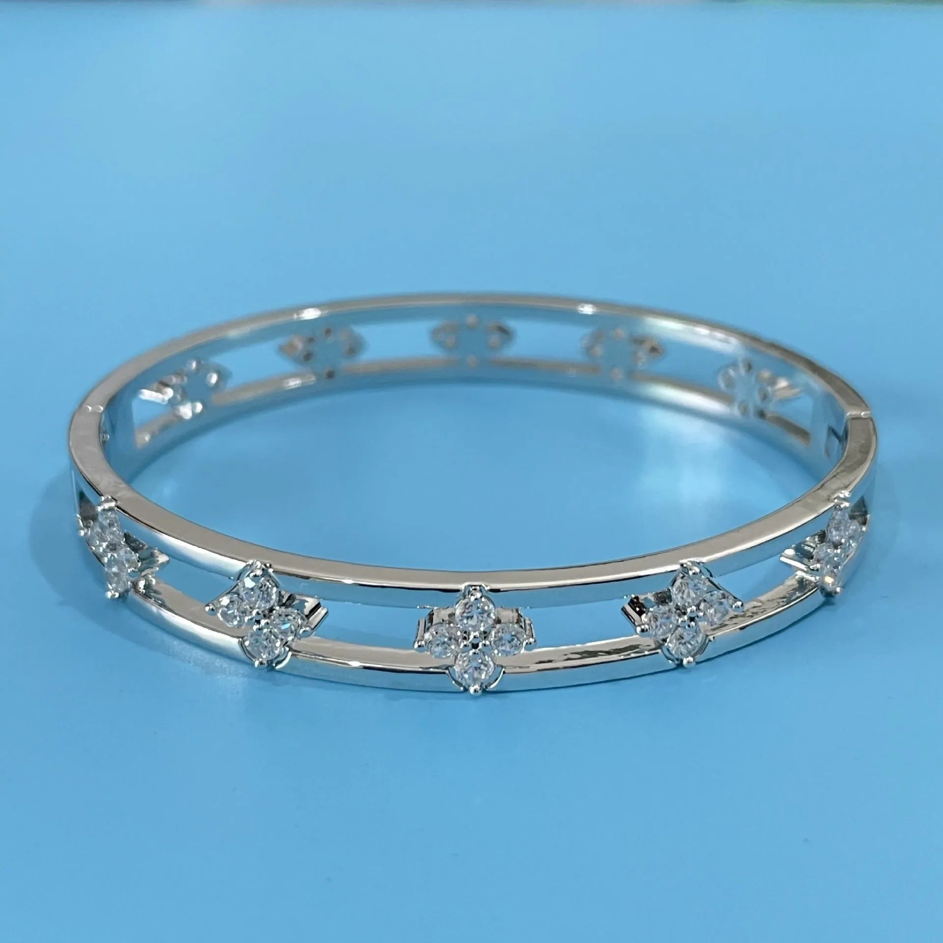 Women's hollow bracelet with zircon stones and four-leaf clover charm in gold and silver options