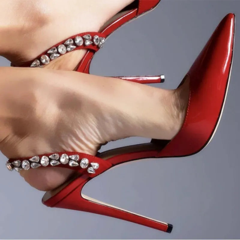 Women's patent leather high heel sandals with pointed toe, clear ankle strap, and rhinestone details.