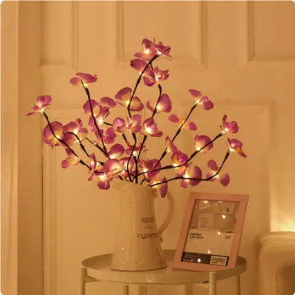 Pink LED Phalaenopsis branch decorative light on a table, 65cm long with fabric cover.