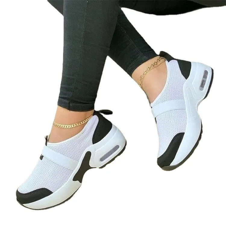 Women's white mesh flat sneakers with round toe and colour stitching on a rubber sole.