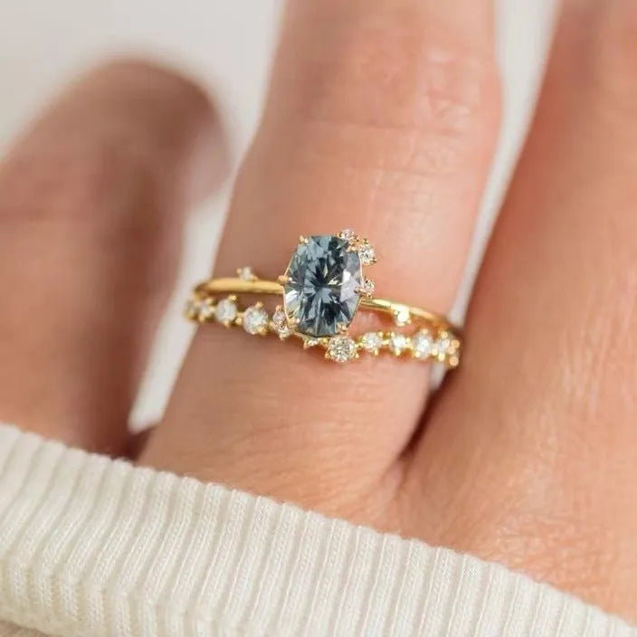 Gold plated women's ring with green zircon stone in flower-shaped design on finger