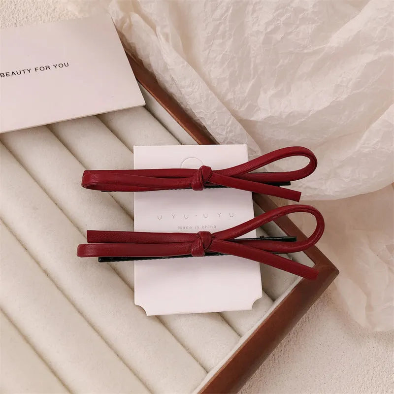 Wine red leather bow barrettes hair clips showing bow design and leather material