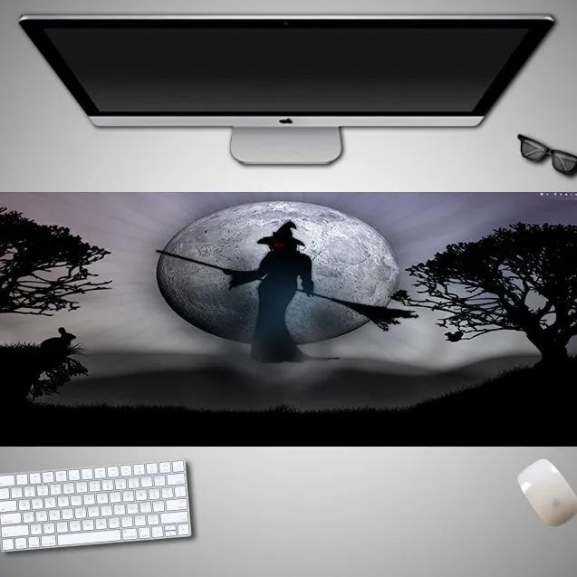 Oversized Halloween graphic cloth mouse pad on a desk, showing non-slip rubber base.