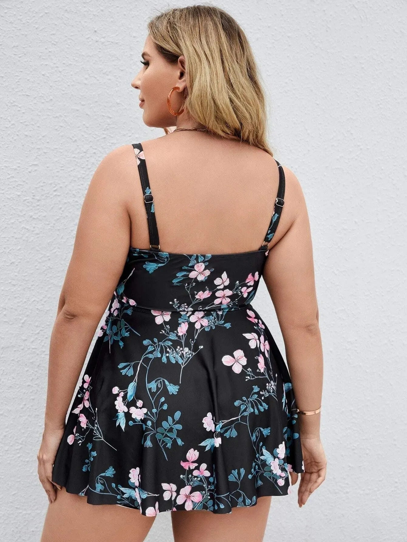Women's one-piece floral print swimsuit with split colour design on a mannequin, showing high elasticity polyester fabric.