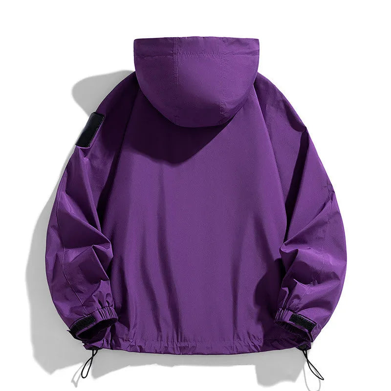 Man wearing a black hooded waterproof windproof jacket with long sleeves.