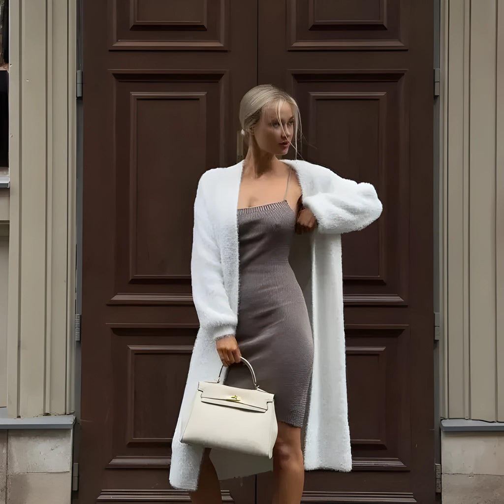 Long white knitted cardigan jacket with long sleeves on a hanger