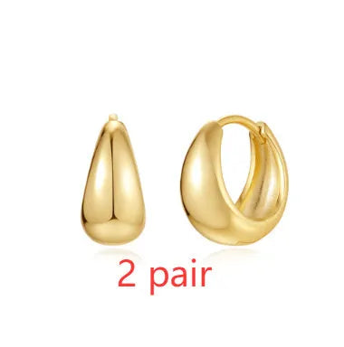 Golden brass earclip earrings with geometric shapes and round elements