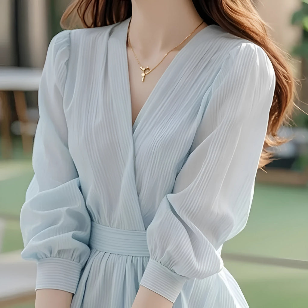 Blue chiffon blouse shirt with loose fit and long sleeves on a hanger