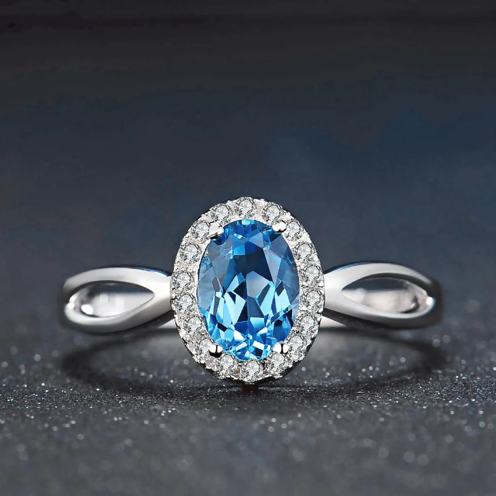Women's 925 silver blue topaz jewellery set showing geometric earrings, ring, pendant and necklace.
