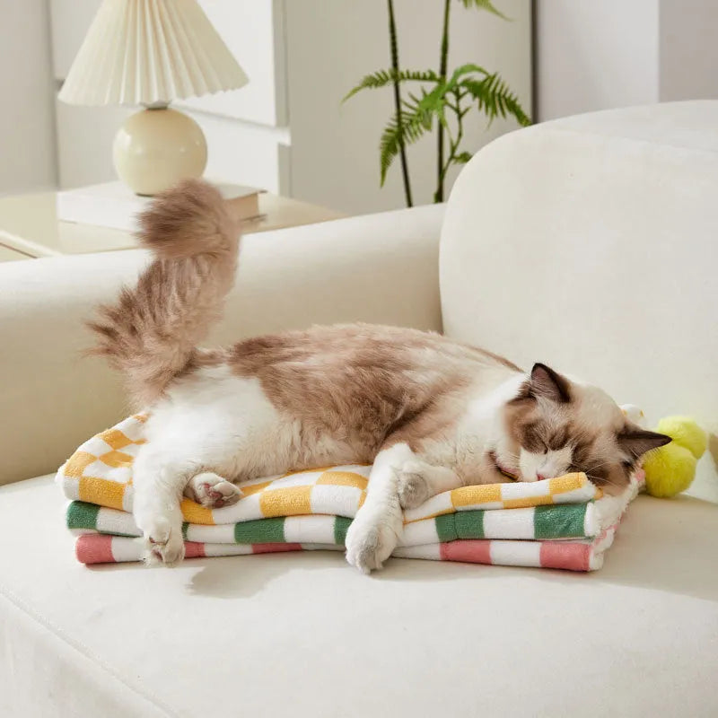 Green plaid pattern plush pet blanket for cats and dogs on a sofa