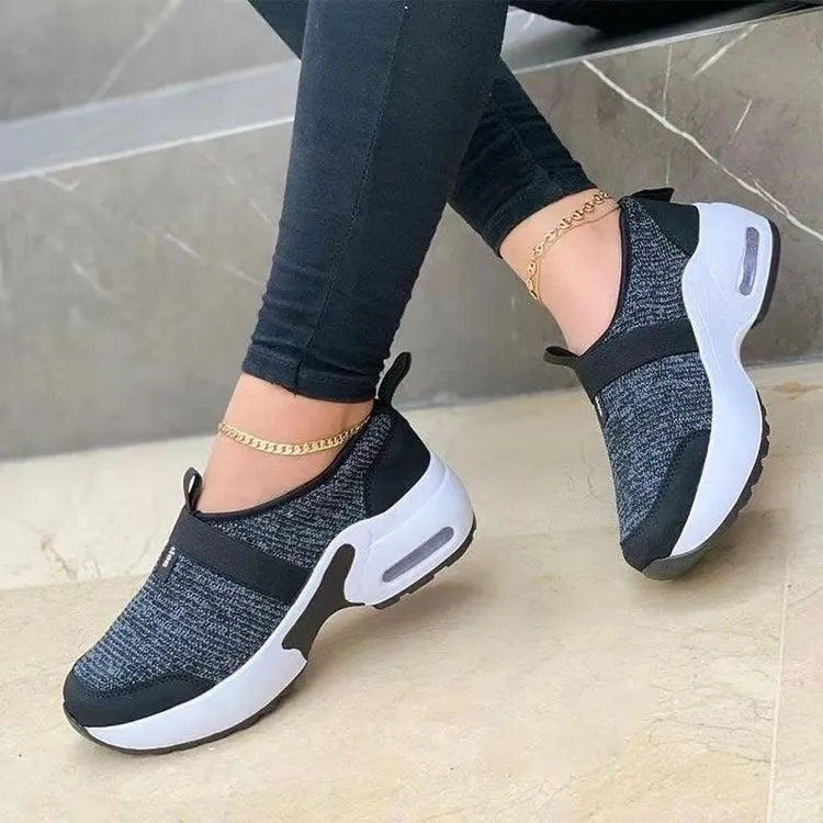 Women's white mesh flat sneakers with round toe and colour stitching on a rubber sole.