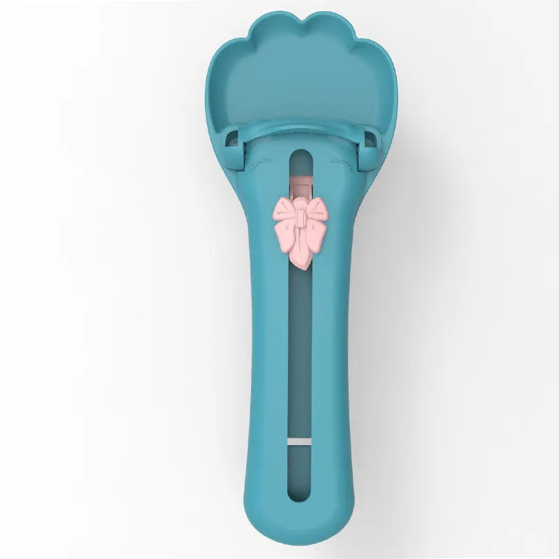 Green and pink pet feed spoon and snack squeezer tool for cat and dog food.