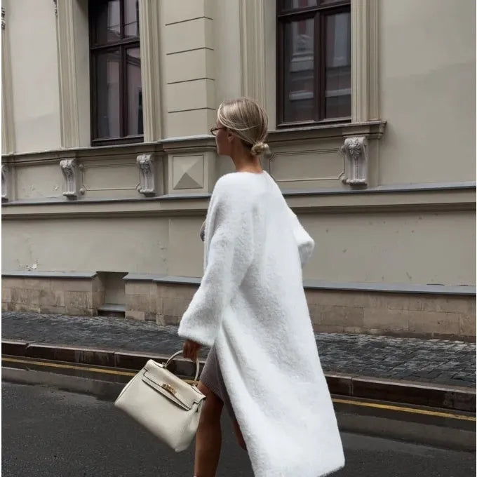 Long white knitted cardigan jacket with long sleeves on a hanger
