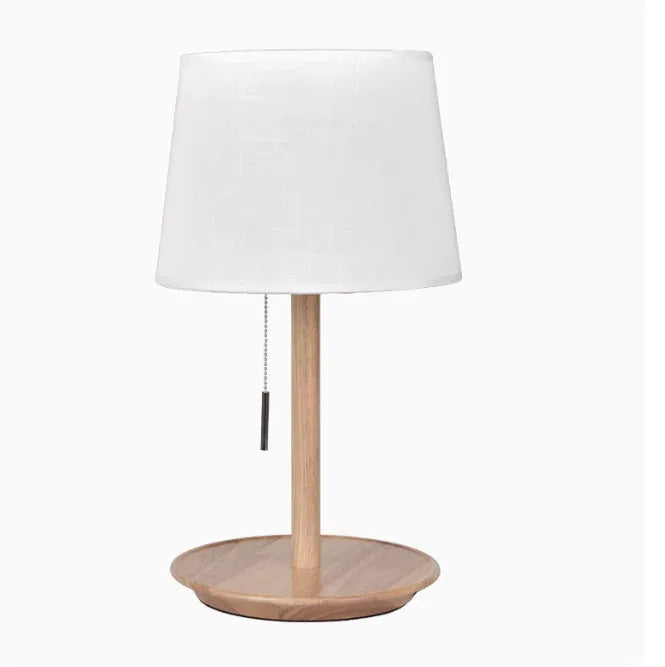 Walnut coloured solid wood bedside table lamp with a white cloth lampshade.