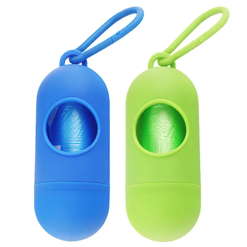Black plastic dog poop bag holder with a metal side hook and Velcro strap, showing compact size.