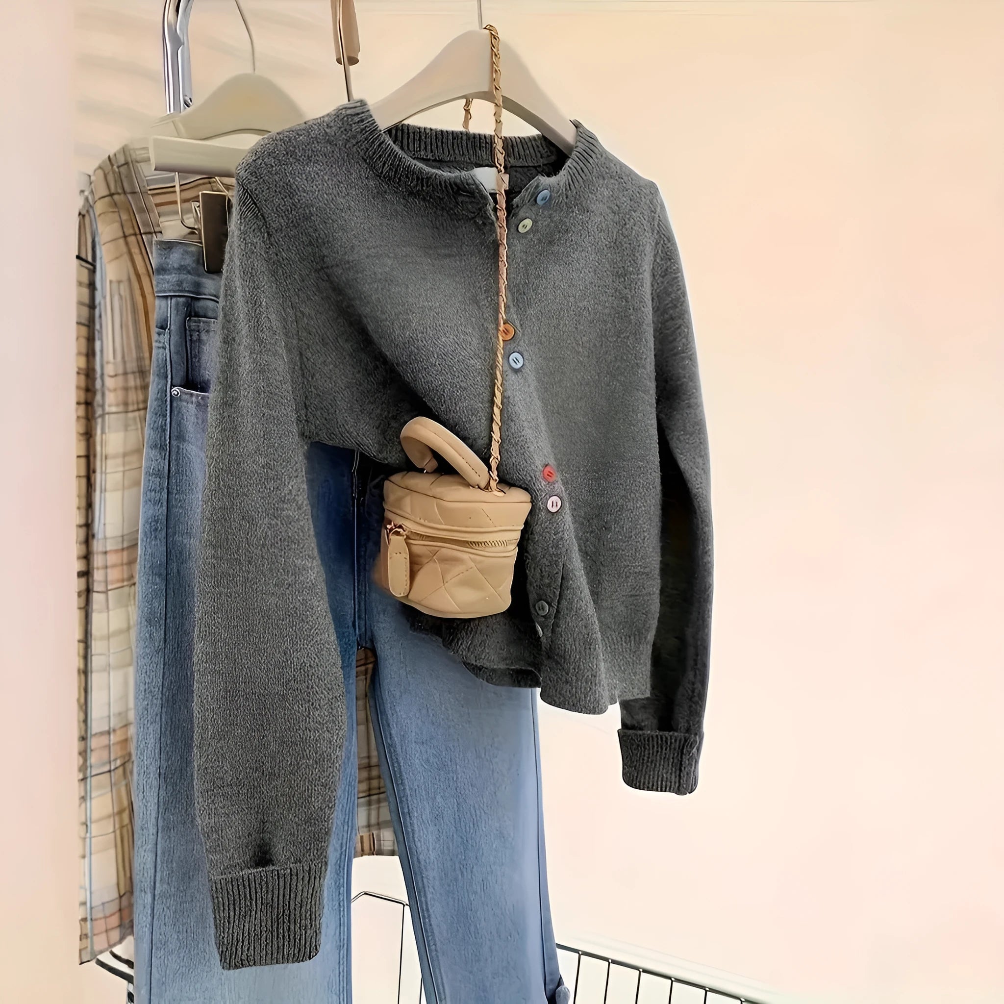 Dark grey solid colour women's polyester cardigan sweater with button front and long sleeves.