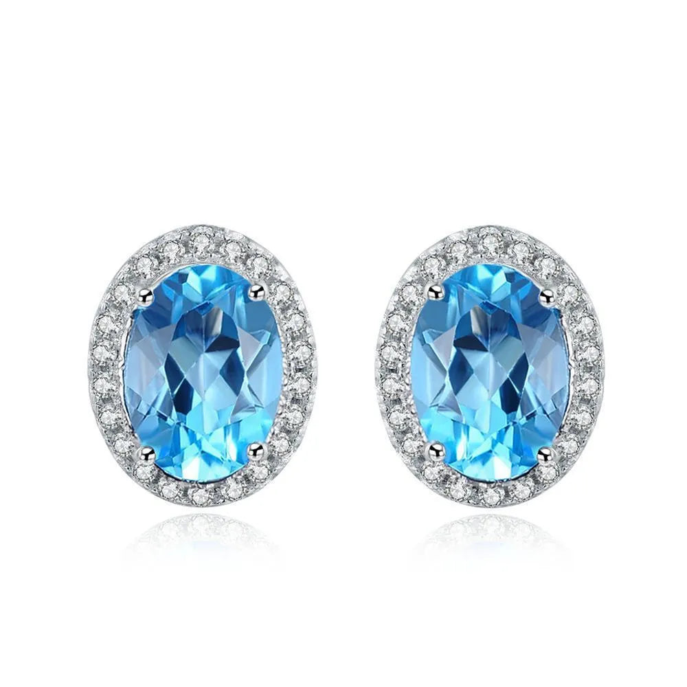 Women's 925 silver blue topaz jewellery set showing geometric earrings, ring, pendant and necklace.