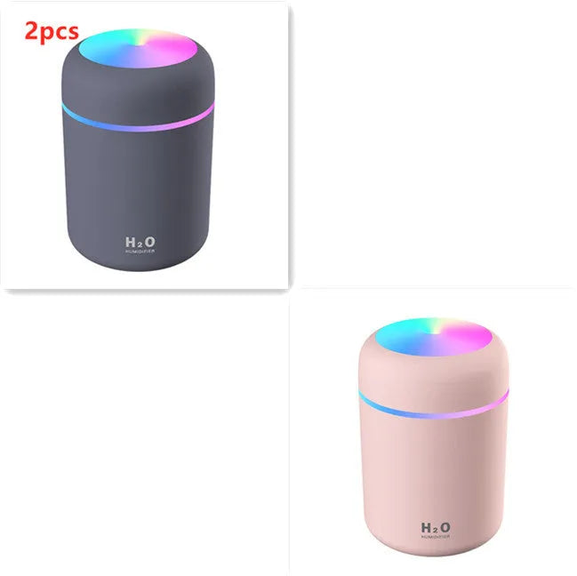 Pink USB desktop humidifier with colourful LED lights and 300ml water tank on wooden desk