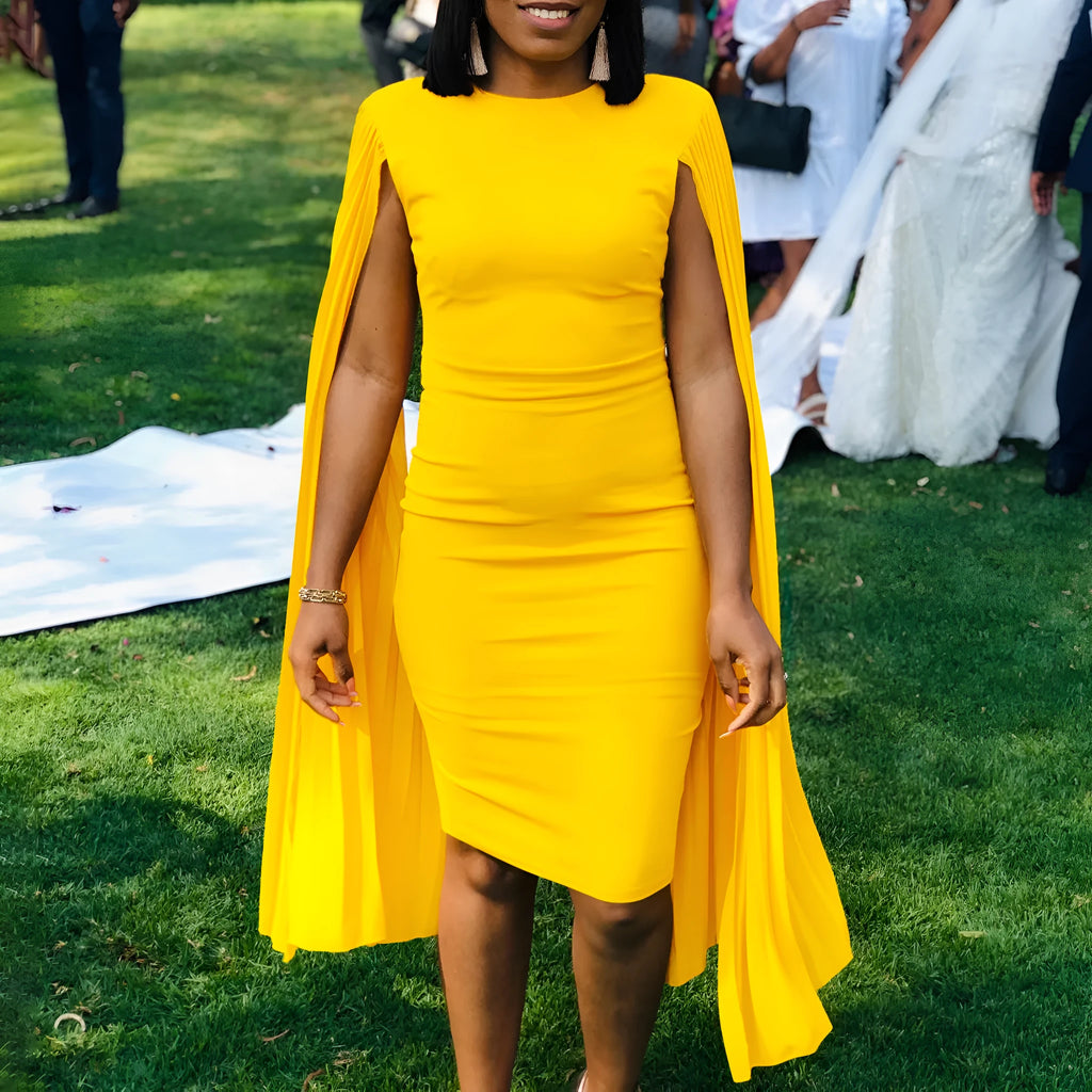 Yellow long sleeve evening gown with a high waist and pleated shawl collar on a mannequin.