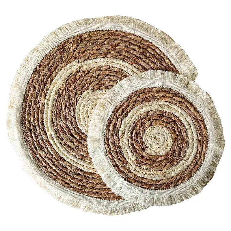 Round Japanese straw placemat with corn rope tassel detailing on wooden table