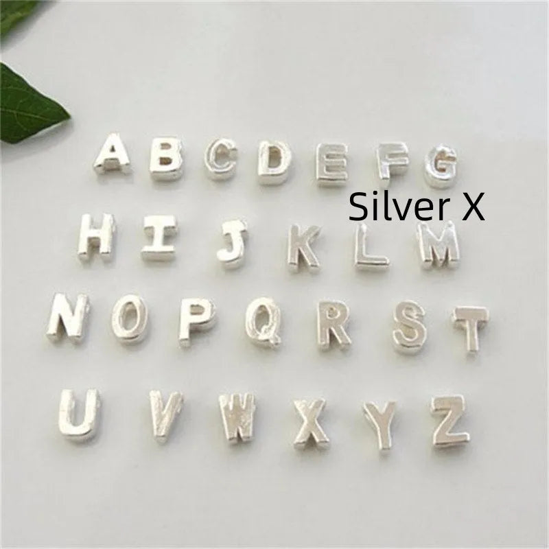 Golden peach heart shaped alloy necklace pendant with a letter design on a white background.