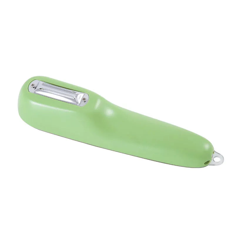 Green vegetable peeler with storage tube, non-slip handle, and hang hole on a kitchen worktop.