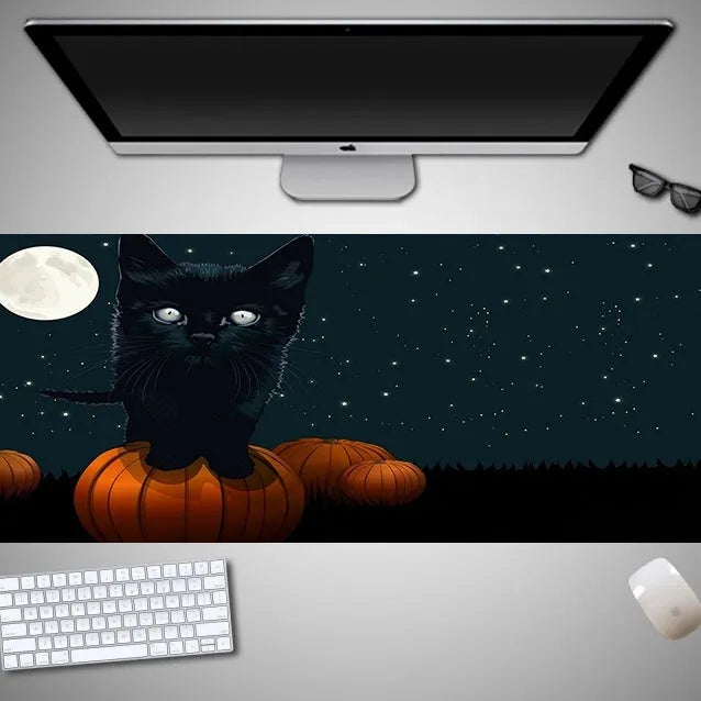 Oversized Halloween graphic cloth mouse pad on a desk, showing non-slip rubber base.