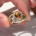Gold-toned copper ring with embossed feather pattern and a central yellow zircon stone on a geometric band.