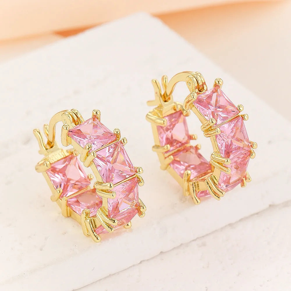 Geometric U-shaped gold-tone earrings with black zircon stones, approximately 20mm diameter