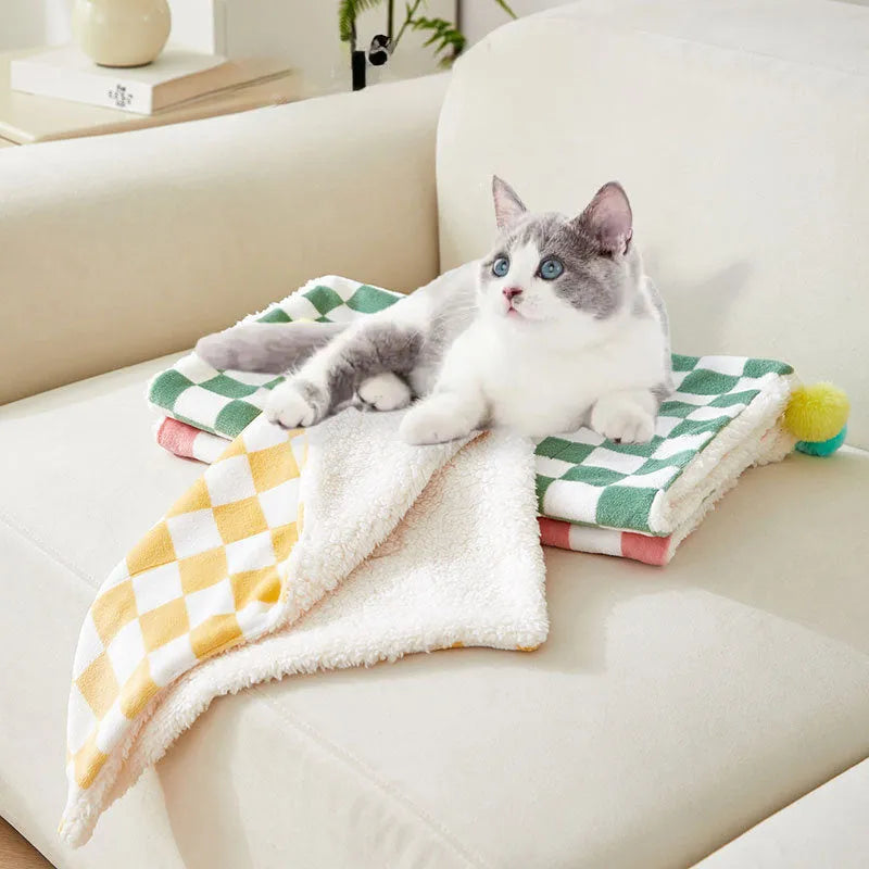 Green plaid pattern plush pet blanket for cats and dogs on a sofa
