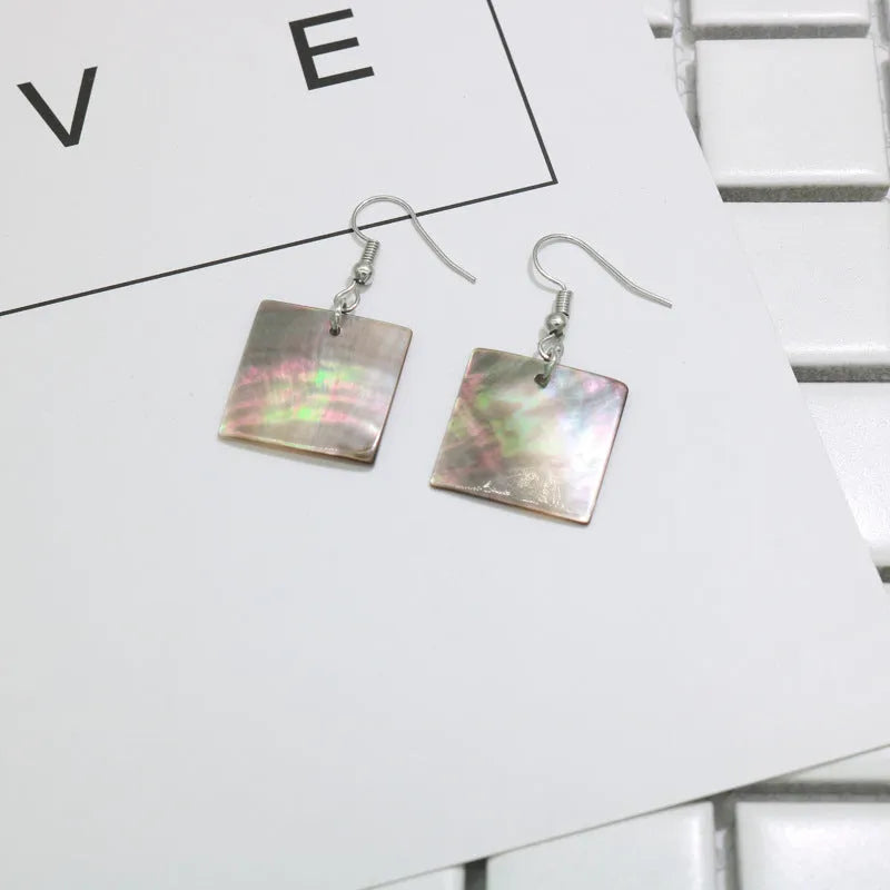 A pair of geometric-shaped earrings made from shell in a retro style, showing colour options.