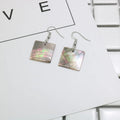 A pair of geometric-shaped earrings made from shell in a retro style, showing colour options.