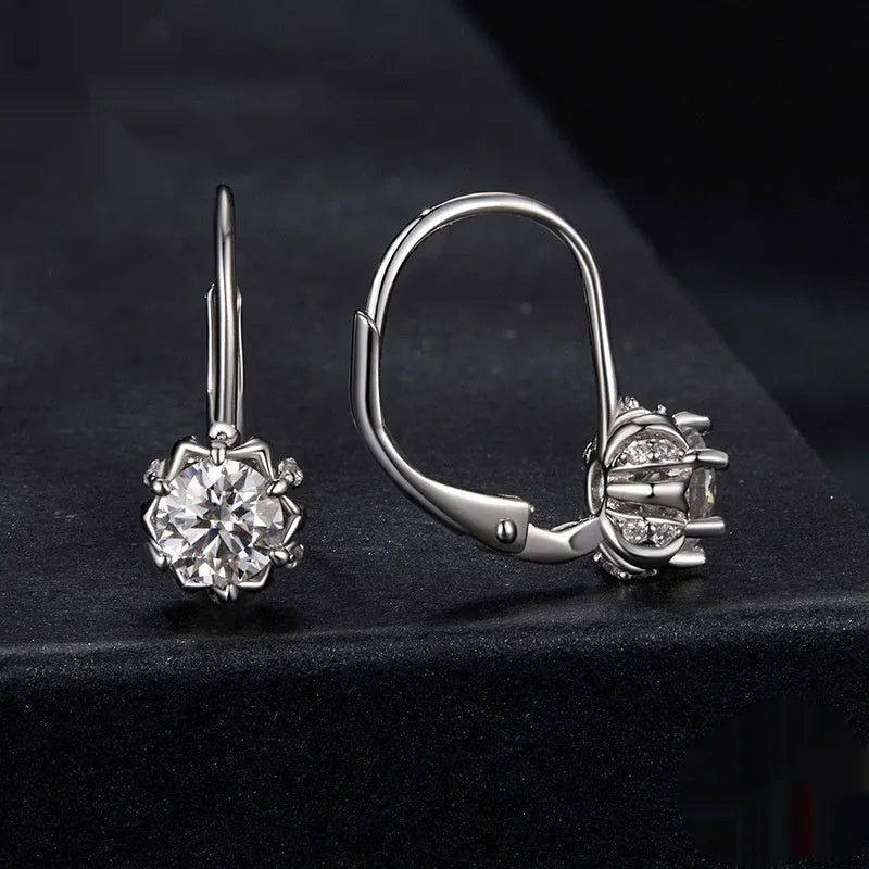 Sterling silver flower bud ear clip with white gold plating and a central moissanite stone.