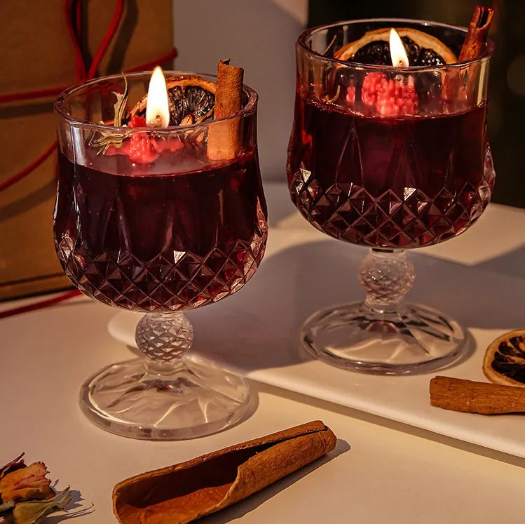 French mulled wine scented candle in a clear glass goblet on a table