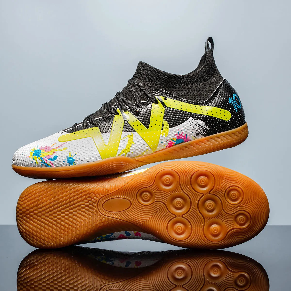 Low-top black and yellow football trainers with removable screw-in studs on the sole.