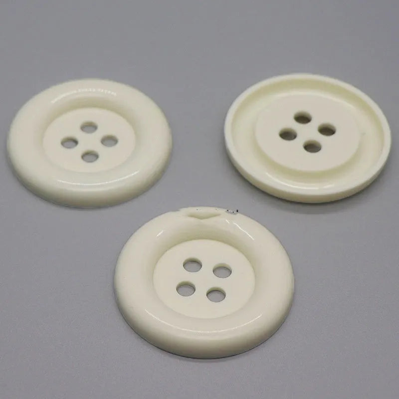 Assortment of oversized round plastic buttons in various colours with four holes.