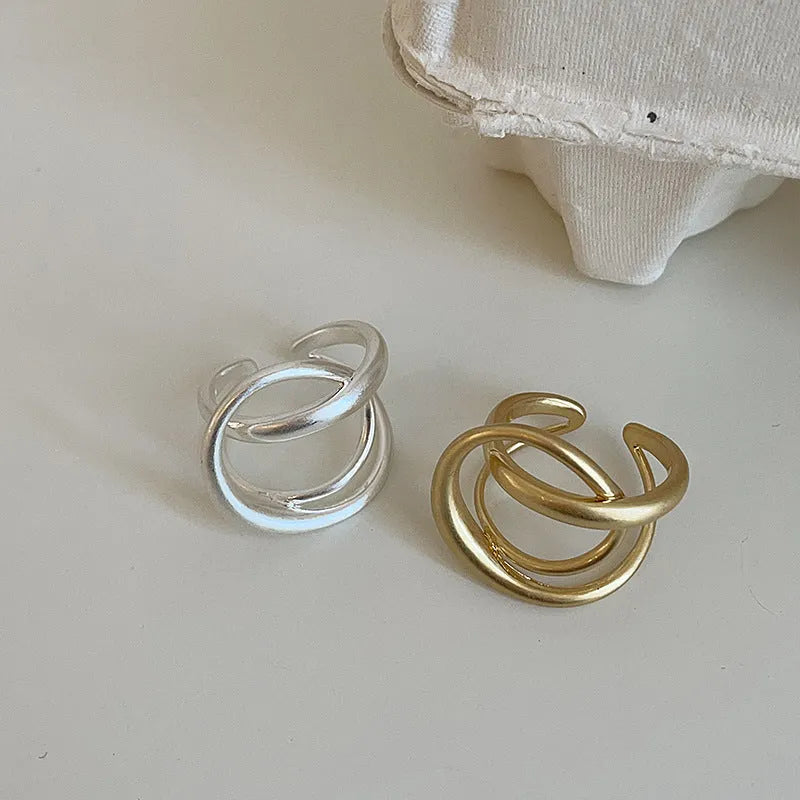 Geometric open ring with three-dimensional interlaced metal design in gold or silver colour