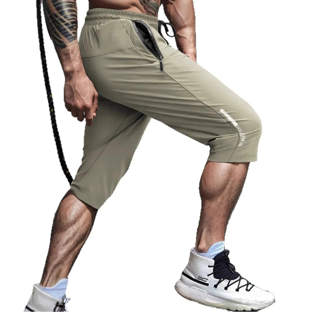 Man wearing grey cropped ice silk sports pants made from quick-dry nylon fabric.