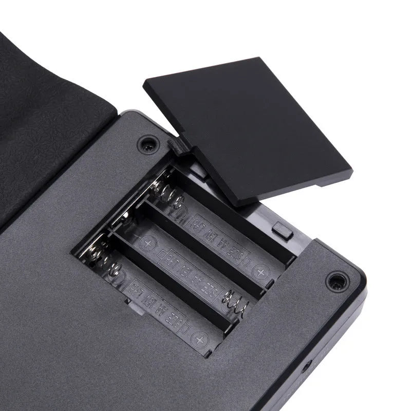 Portable folding 49-key electronic keyboard with speaker in compact rolled position showing silicone rubber keys and ABS plastic controls