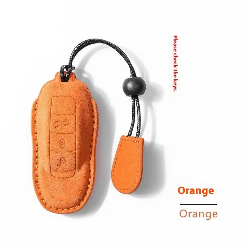 Suede car key cover in cement grey, dark green, light grey, and orange colour options.