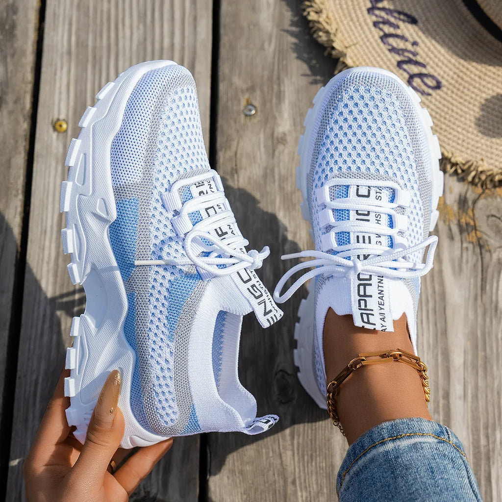 Women's lace-up Flyknit mesh sneakers in a grey colour combination with a round toe and flat rubber sole.