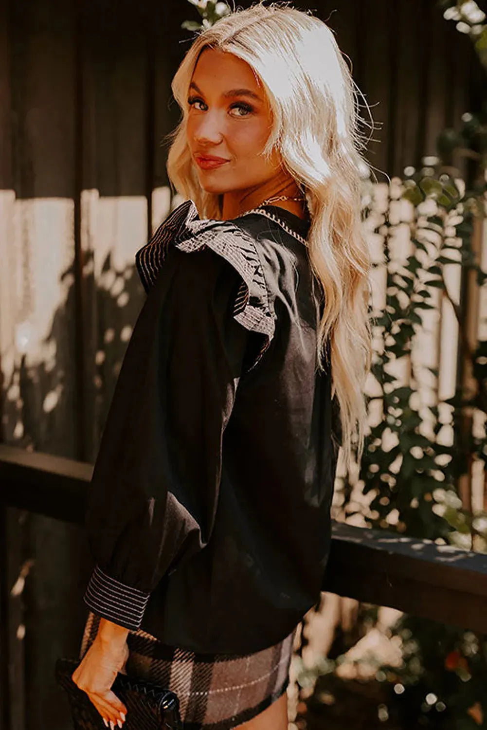Black women's blouse with V-neck, contrast stitching and long ruffle sleeves