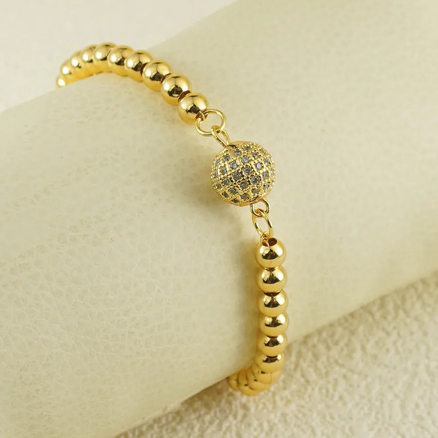 Close-up of a women's copper bracelet with a heart-shaped centre holding a single round zircon stone.