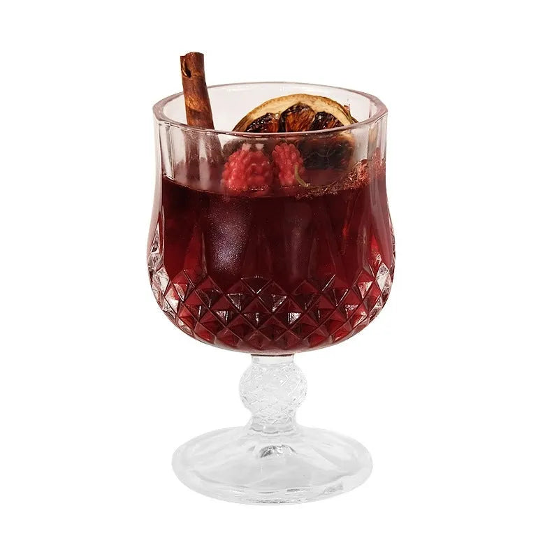 French mulled wine scented candle in a clear glass goblet on a table