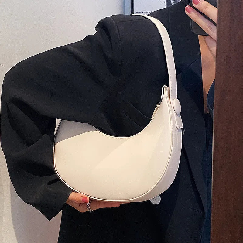 Women's retro dumpling-shaped PU leather shoulder bag in black showing sandwich pockets and zippered compartment