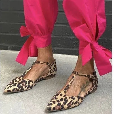 Leopard print women's pumps with pointed toe and chunky low heel, featuring cross shoulder straps