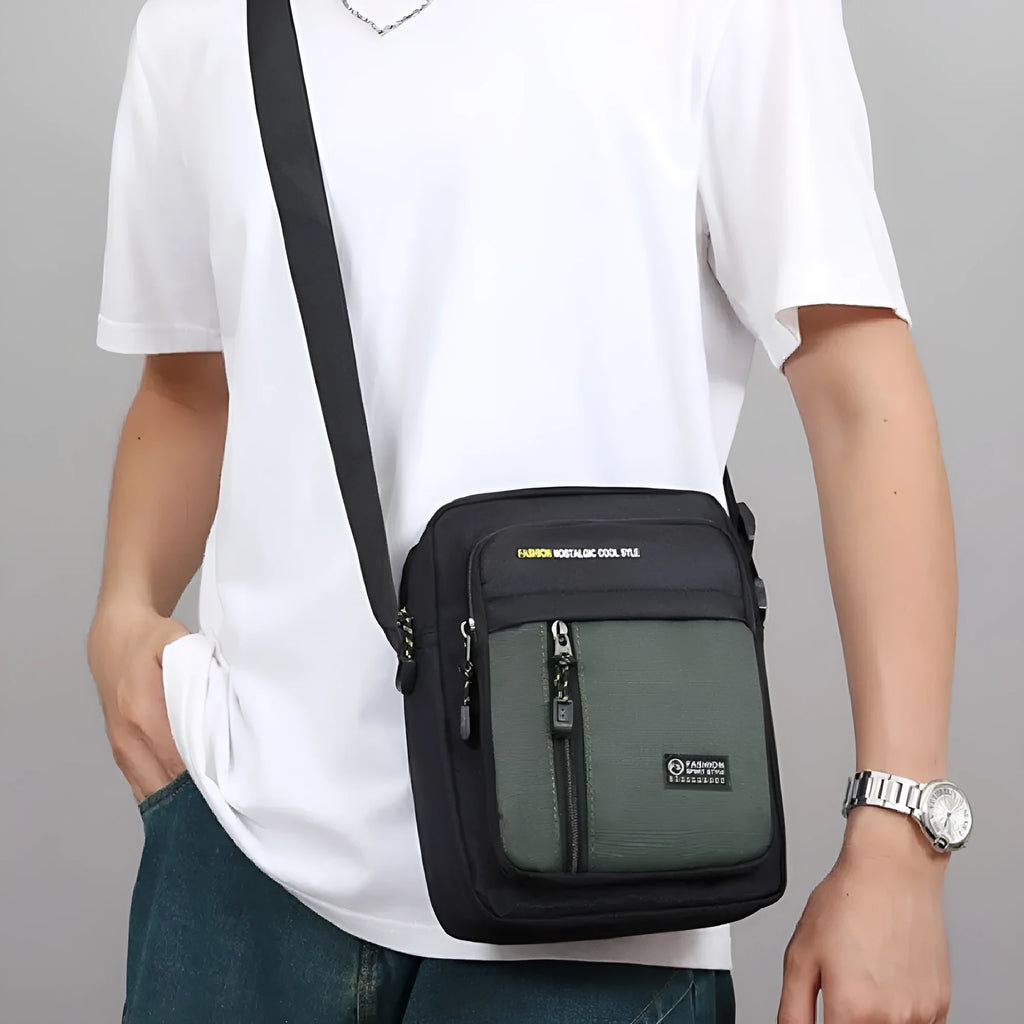 Men's casual nylon crossbody messenger bag in green, shown from the front with sewing thread detail.