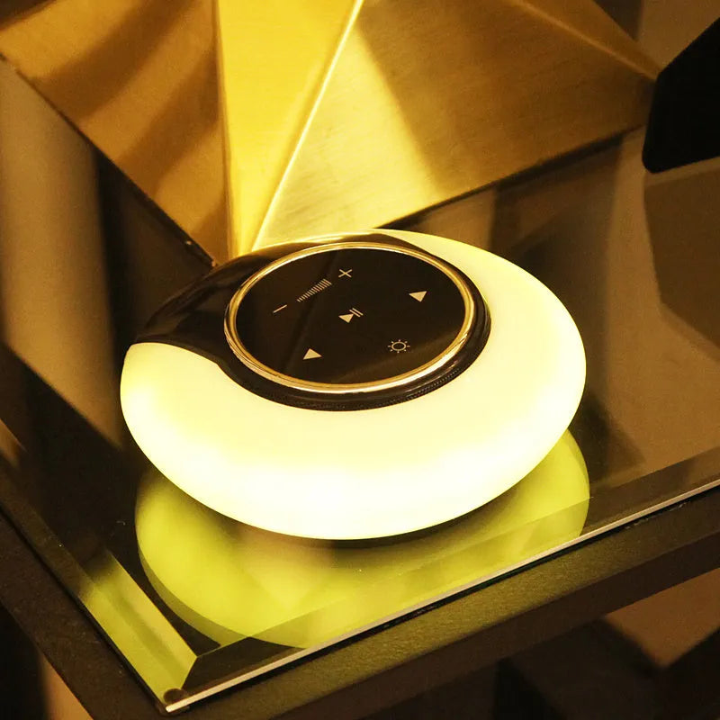 Blue folding Bluetooth speaker desk lamp with touch controls showing white, yellow, and blue LED lighting options